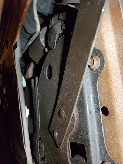 1978 Ford Bronco - This is a close-up, angled shot of a rusty metal mechanism with a large gear and a lever, possibly part of a seat adjustment or parking bra…