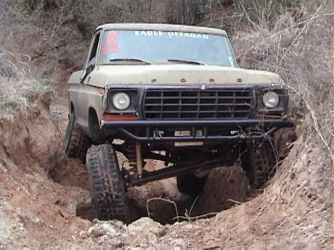 1978 Ford Bronco - This Ford truck is navigating a difficult off-road trail with its front wheels angled.