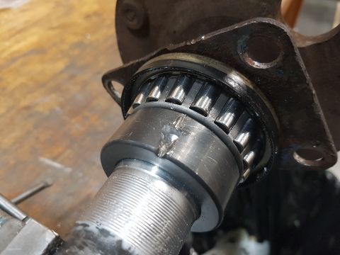 1978 Ford Bronco - A close-up view of a damaged wheel bearing assembly, showing the roller bearings and a metal flange, with a watermark for SuperMotors.net.