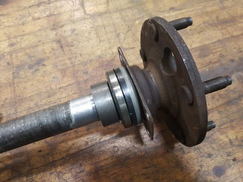 1978 Ford Bronco - Close-up of an axle shaft with a hub and bearing assembly, likely a vehicle part.