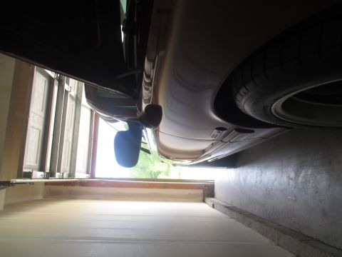 2004 Ford Crown Victoria - The side profile of a 2004 Ford Crown Victoria is visible from a low angle, revealing the tire and side mirror.
