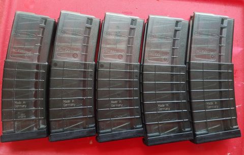 2000 Ford Crown Victoria - A group of five rifle magazines, all manufactured in Germany, are displayed on a red surface.
