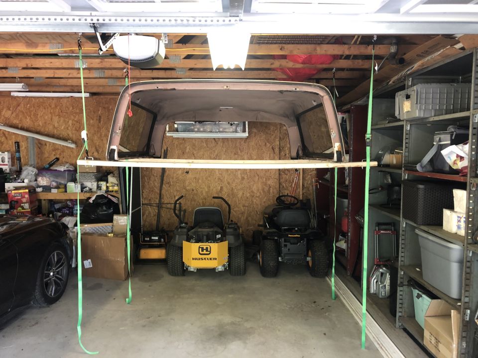 While the top itself isn't that heavy (It is a bit awkward) it's easy enough to remove / replace solo - but storage is another matter. I put this simple, easy storage setup together for @ $30 and maybe an hour's work if that.  (2) 8 foot 2x4's with clamped brackets in each end. An eye lag hook in the rafter 2x4 and a set of (4) ratchet straps. Unbolt the top from inside the truck, ease the top up on your back / shoulders and slide the 2x4's under the top. Tighten the ratchet straps evenly on each side until you can drive out from under it.