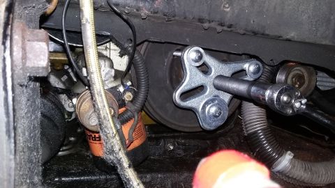 Engine part with a tool attached to a pulley