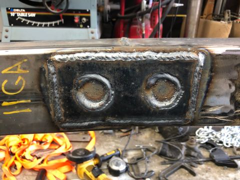 1992 Jeep Wrangler - Close-up of a welded frame section, showing two circular openings and yellow markings.