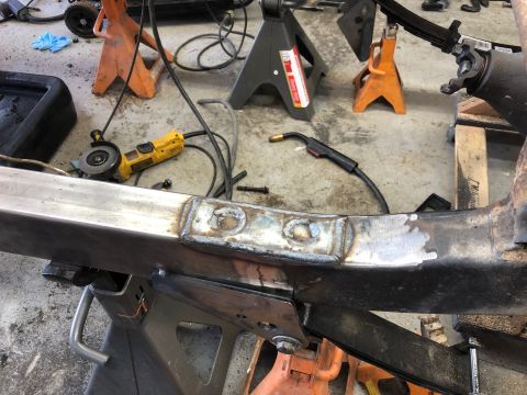 1992 Jeep Wrangler - A vehicle frame is being worked on with welding equipment and tools in a garage setting.
