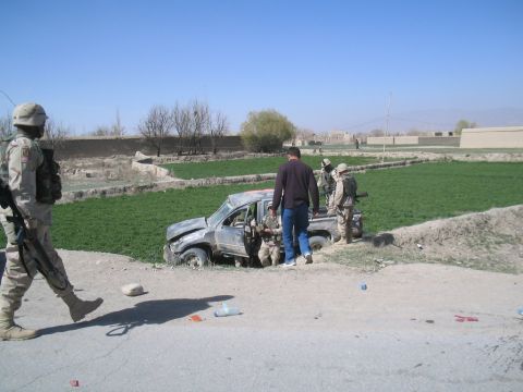 1981 Ford Bronco - Soldiers and a civilian stand near a damaged pickup truck in a ditch.