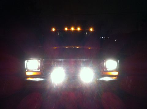 1978 Ford Bronco - Front view of a 1978 Ford Bronco at night, with its headlights and roof marker lights on.