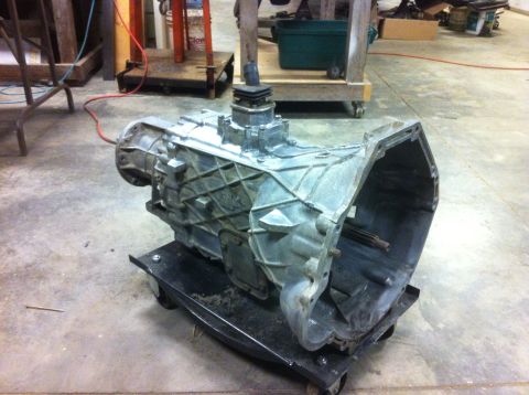 1978 Ford Bronco - A transmission sits on a rolling dolly in a workshop environment, awaiting further work or installation.