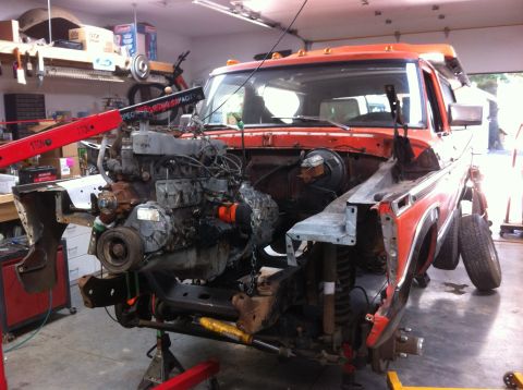 1978 Ford Bronco - Orange 1978 Ford Bronco undergoing engine removal in a workshop.