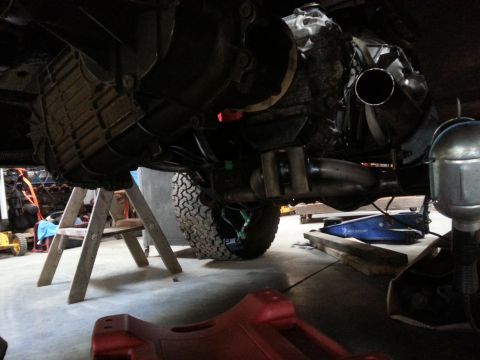 1978 Ford Bronco - Vehicle's transmission and exhaust system are visible from underneath, supported by jack stands.