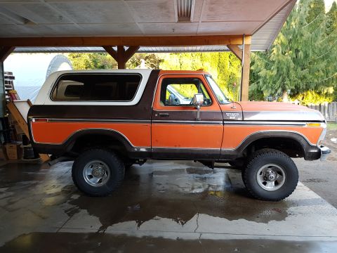 1978 Ford Bronco - This two-tone orange and brown 1978 Ford Bronco is shown from the side, parked under a covered structure.