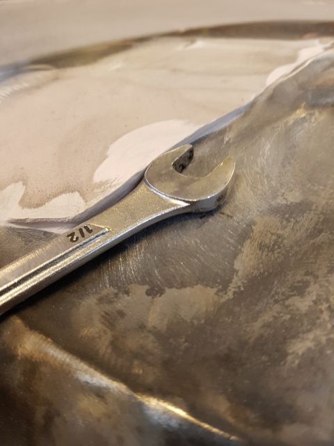 1978 Ford Bronco - A 1/2 inch wrench lies on a metal surface, possibly a car body panel undergoing repair.