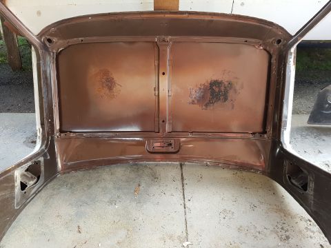 1978 Ford Bronco - The interior of a vehicle's roof and upper door frames are shown, with visible rust and a central latch mechanism.