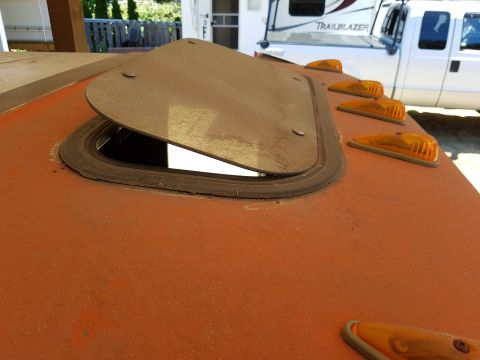 1978 Ford Bronco - Close-up of an RV's orange roof with an open hatch, showing a white truck and trailer in the background.
