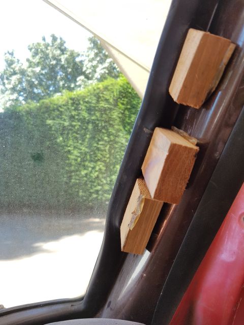 1978 Ford Bronco - Wooden blocks are taped to the interior trim of a vehicle, obscuring the view outside.