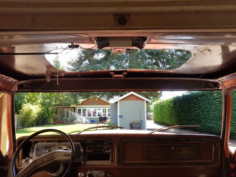 1978 Ford Bronco - View from inside a 1978 Ford Bronco, looking out at a backyard scene through the windshield.