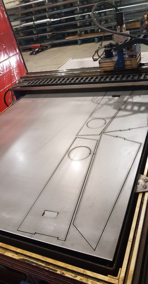 1978 Ford Bronco - A CNC plasma cutter is shown in operation, cutting shapes into a large sheet of metal in a workshop.