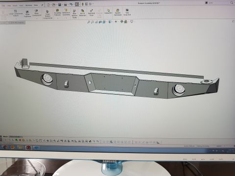 1978 Ford Bronco - SolidWorks model of a complete custom front bumper assembly featuring a center winch recess and two round driving-light mounts at the ends.