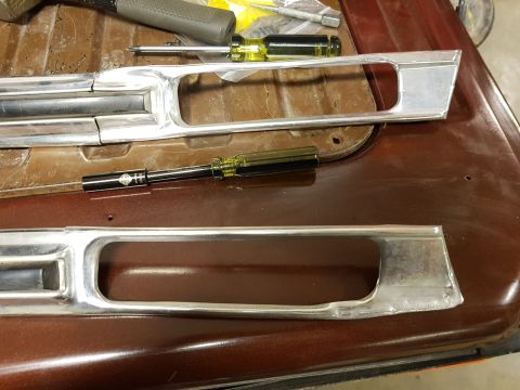1978 Ford Bronco - Chrome trim pieces and tools are laid out on a brown surface, possibly for repair or installation.