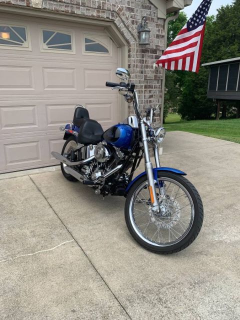2008 Harley-Davidson Softail - A blue motorcycle is parked on a concrete driveway in front of a suburban garage.