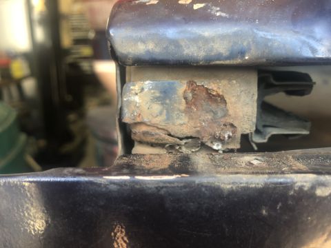 1995 Ford Bronco - Rusted metal bracket and rubber seal visible on a vehicle part.