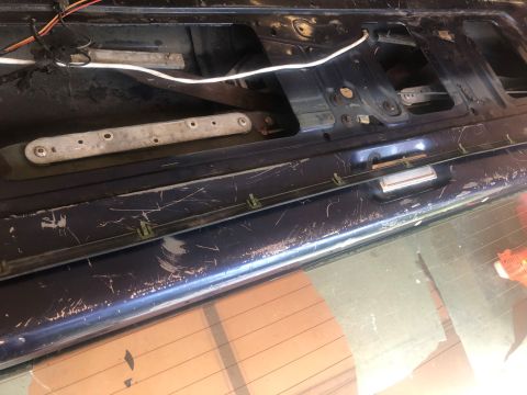 1995 Ford Bronco - Interior view of a car's tailgate, showing mechanical components and signs of wear.