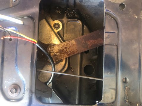 1995 Ford Bronco - Close-up view of the internal tailgate latch mechanism, showing wires and a rusty metal component.