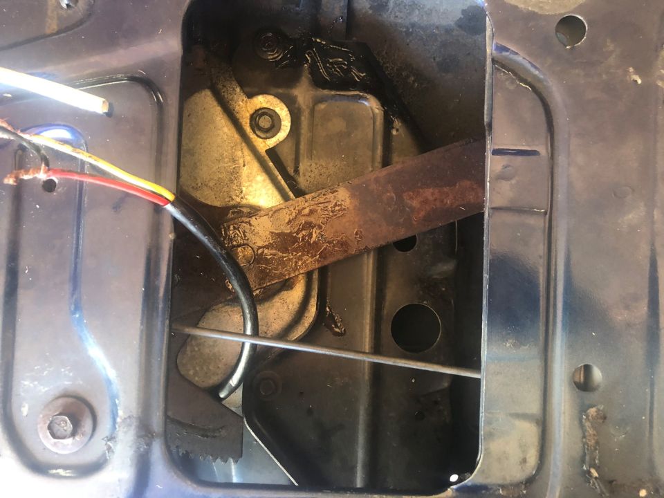 Tailgate latch mechanism with wires and rusty metal bar
