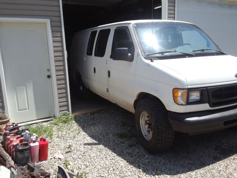 1999 Ford E250 - White 1999 Ford E250 cargo van is partially inside a garage.