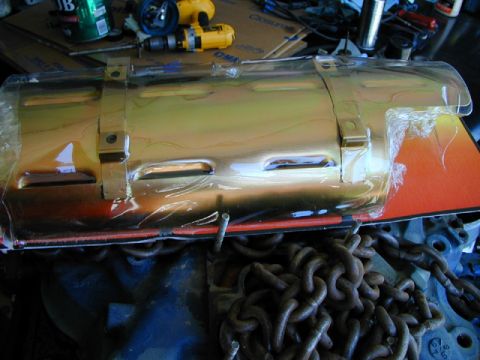 1979 Ford Bronco - Engine part covered in plastic wrap, with heavy chains in the foreground.