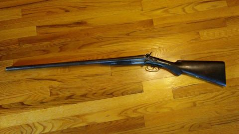1994 Ford Bronco - A double barrel shotgun is displayed on a polished wooden floor.