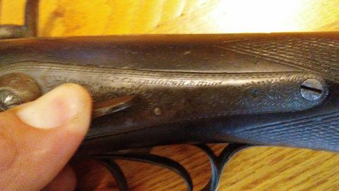 1994 Ford Bronco - Engraved text on a firearm part, possibly a shotgun receiver, with decorative scrollwork.