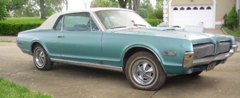 1968 Mercury Cougar - A teal 1968 Mercury Cougar convertible with a white top is parked in a driveway.