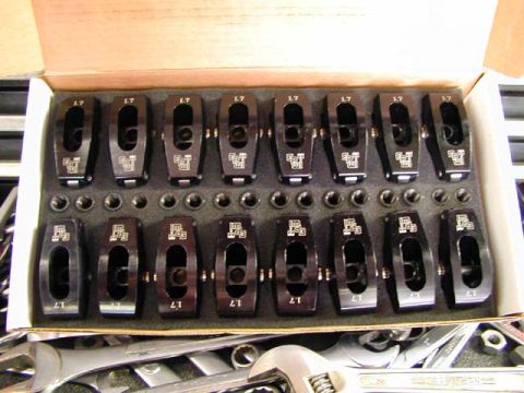 1979 Ford Bronco - A set of 16 black rocker arms are neatly arranged in a box with foam padding.