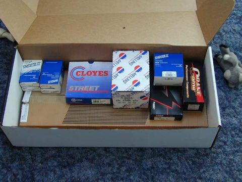 1979 Ford Bronco - A collection of engine performance parts are laid out in an open cardboard box, ready for installation.