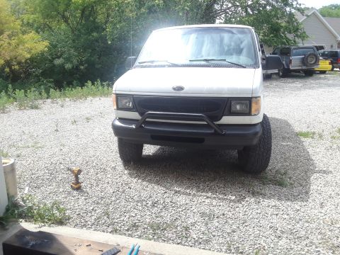 1999 Ford E250 - Front view of a white van, possibly a 1999 Ford E250, with a black grille and bull bar.