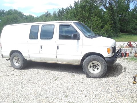 1999 Ford E250 - White 1999 Ford E250 van with aftermarket bumper and off-road tires.