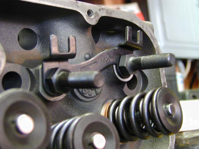 Engine cylinder head part with visible valve springs, rocker arm, and bolt. Text '4858' is visible