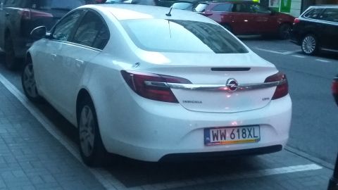 Rear view of white Opel Insignia sedan parked on street, license plate WW 618XL