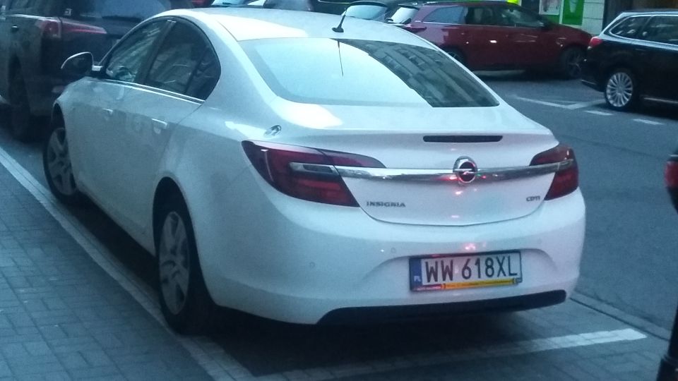 Rear view of white Opel Insignia sedan parked on street, license plate WW 618XL