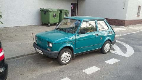 Teal hatchback parked on street with license plate W-226FW