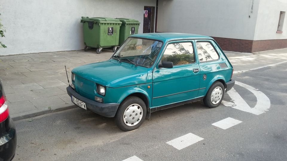 Teal hatchback parked on street with license plate W-226FW