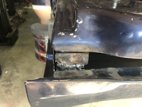 1995 Ford Bronco - Close-up view of a welded repair on the rear quarter panel of a dark blue vehicle, likely undergoing tailgate repair.