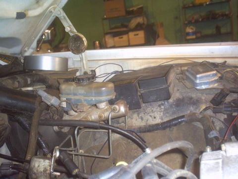 1991 Ford LTD Crown Victoria - Close-up of brake master cylinder and fuse box components in an engine compartment.