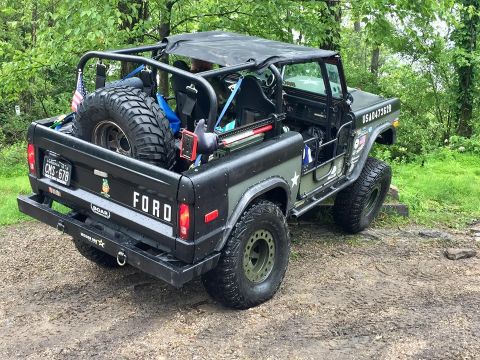 1972 Ford Bronco - This modified 1972 Ford Bronco features a , off-road aesthetic with a roll cage and a large spare tire mounted in the bed.