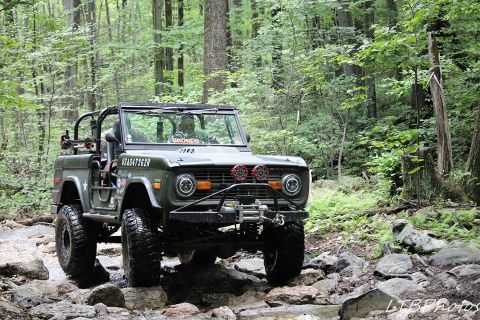 1972 Ford Bronco - This 1972 Ford Bronco is navigating a challenging rocky path through a wooded area.