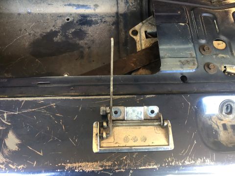 1995 Ford Bronco - Close-up of a vehicle's tailgate latch mechanism, showing wear and tear.