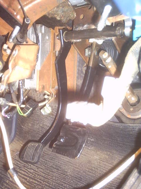 1991 Ford LTD Crown Victoria - Close-up view of the floor pedals and surrounding mechanical components inside a vehicle.