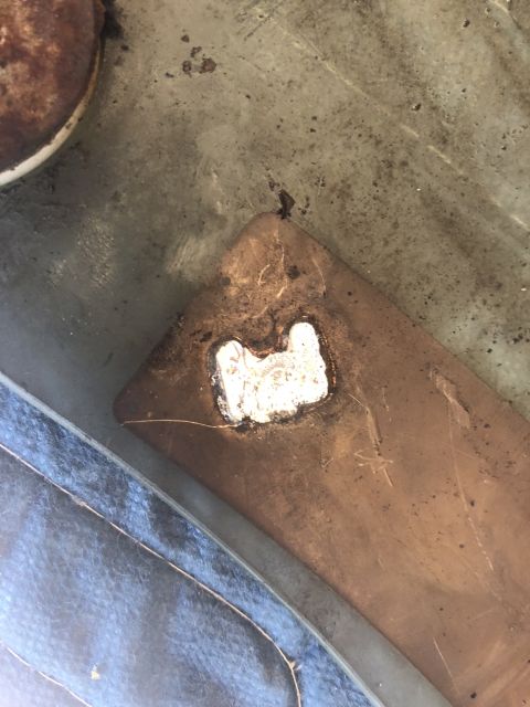 1995 Ford Bronco - Close-up view of a metal tailgate repair patch, showing the white filler material.